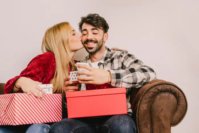 Pareja de novios dándose regalos por san Valentín