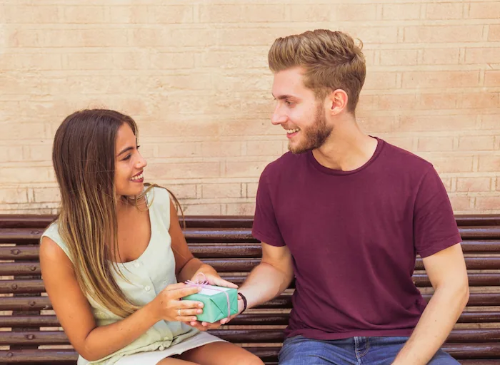 chico dandole detalles a la chica que le gusta con el objetivo de enamorar a una mujer