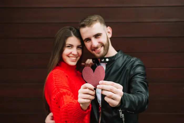 un hombre enamorado junto a su pareja sosteniendo un corazón