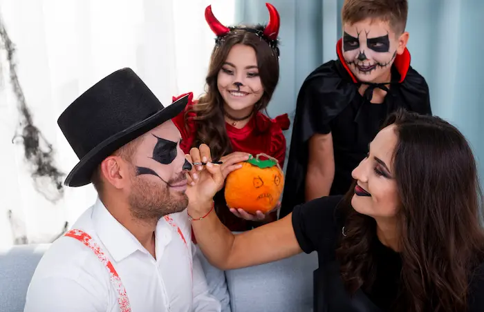 chica maquillando a su amigo con temática de halloween