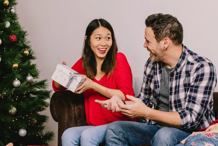 chico dandole un obsequio navideno a una chica